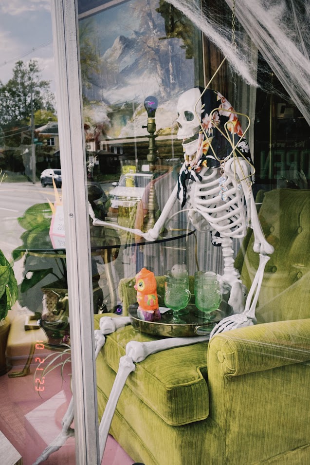 october 21, 2023: a skeleton wearing a babushka sitting in a shop window.